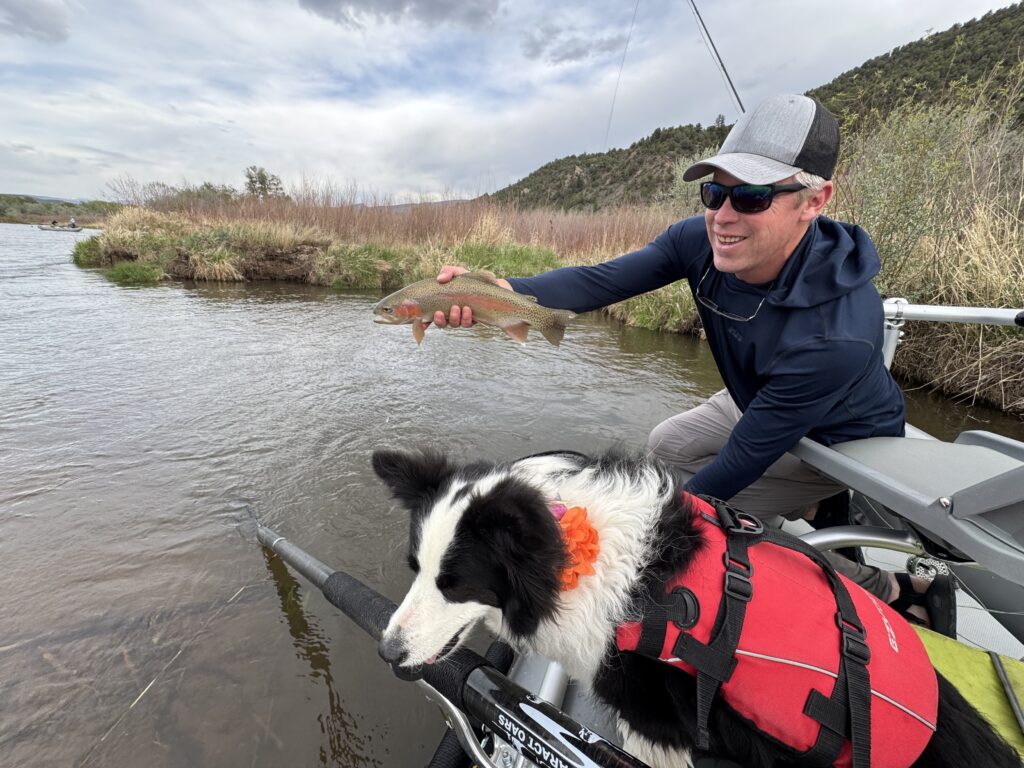 man on a float with fish and dog used Hill's fly fishing flies